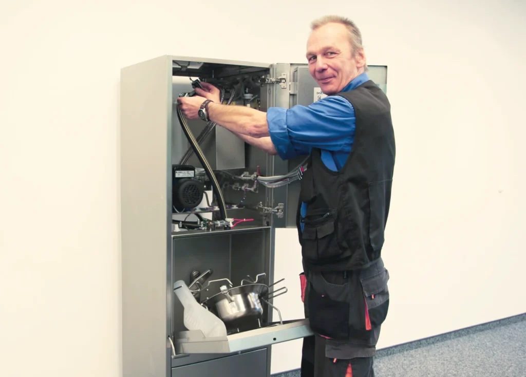 DISCHER service technician maintaining an open bedpan washer